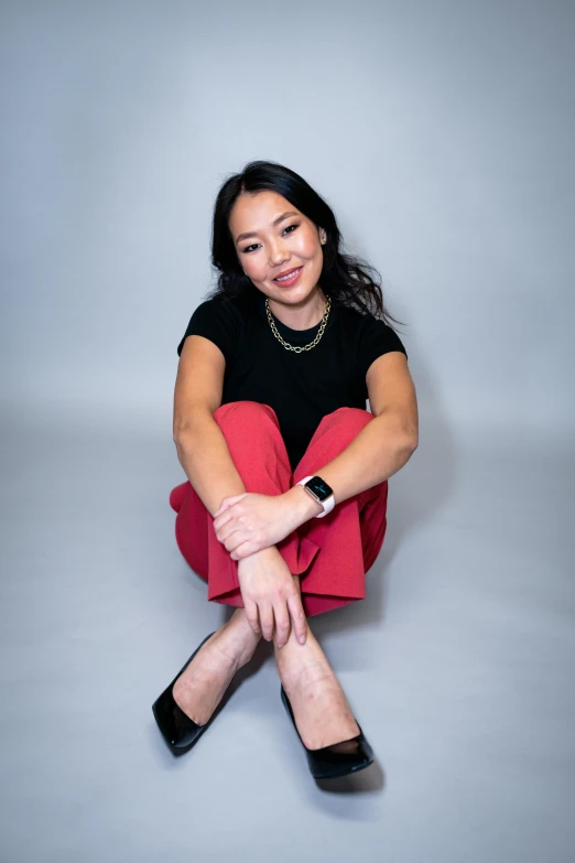 a woman is sitting on the ground with her legs crossed