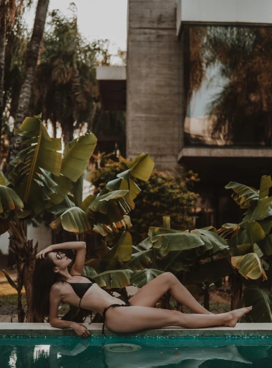 a woman laying down by the edge of a pool