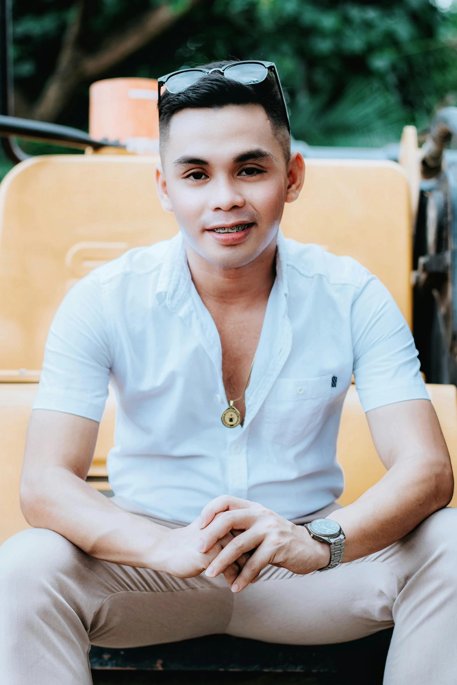 a young man sitting on a chair with sunglasses on