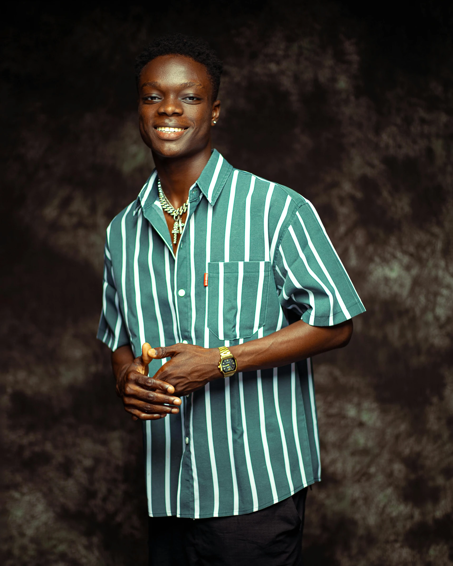 a black man wearing a green striped shirt