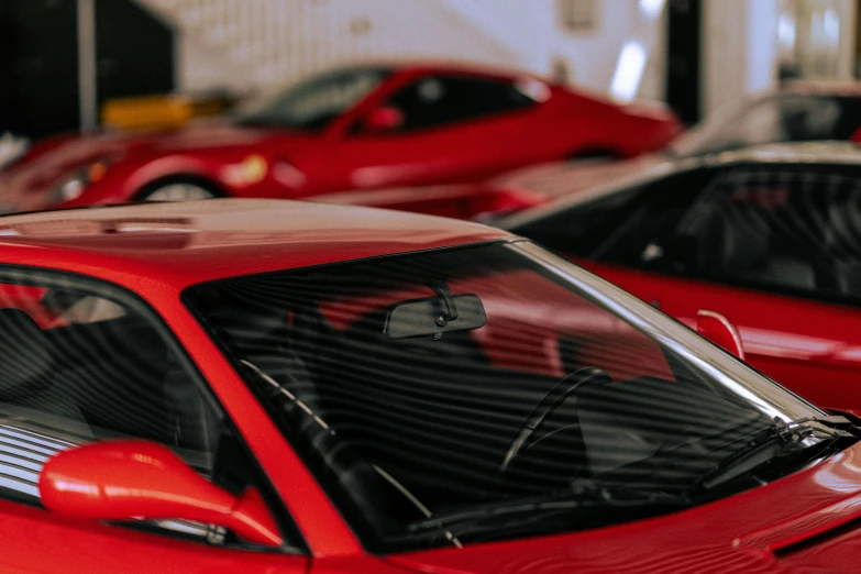 the back end of red cars parked in a garage