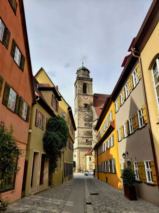 an alley with many cobblestones has a steeple