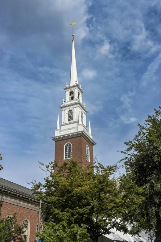 a church steeple under a cloudy blue sky