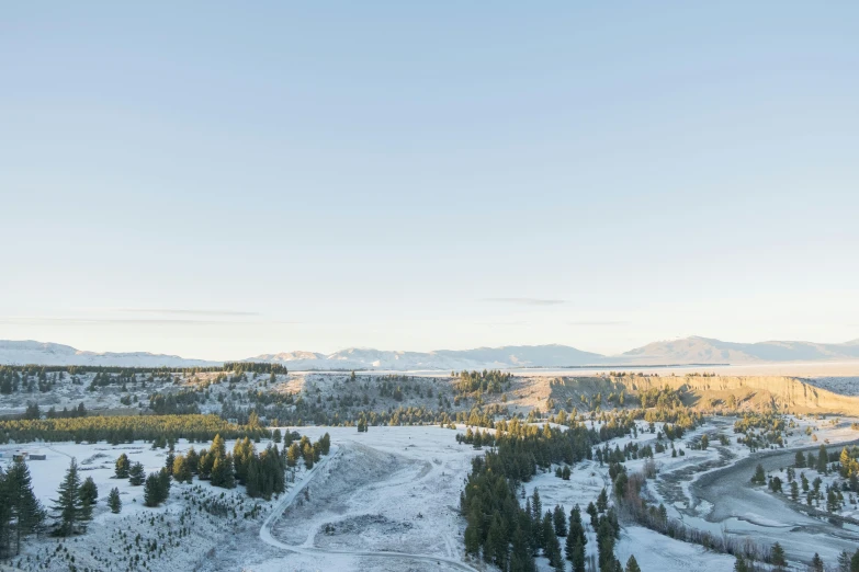 a long road through snowy mountains with trees