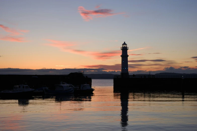 the sky is reflected in the water by the small tower