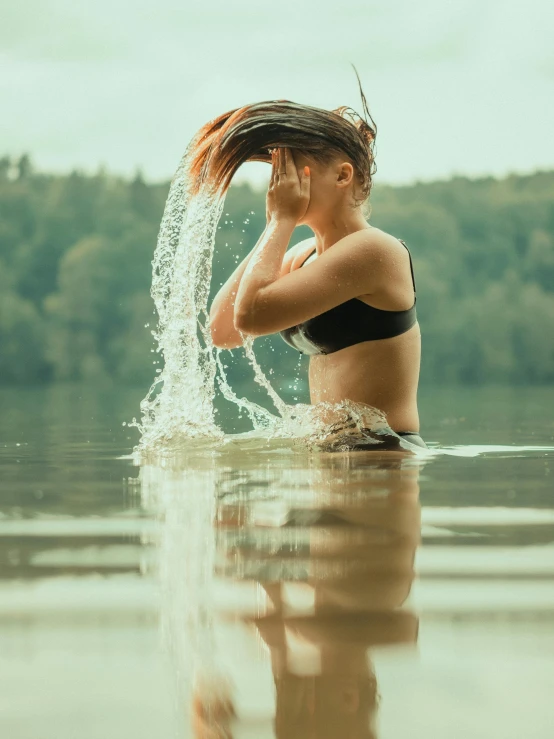 there is a woman splashing water in the lake