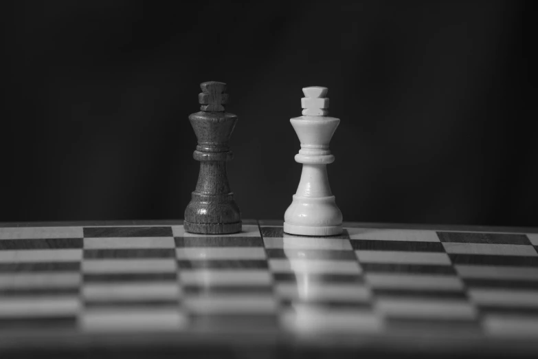 two chess pieces on a black and white checkerboard surface