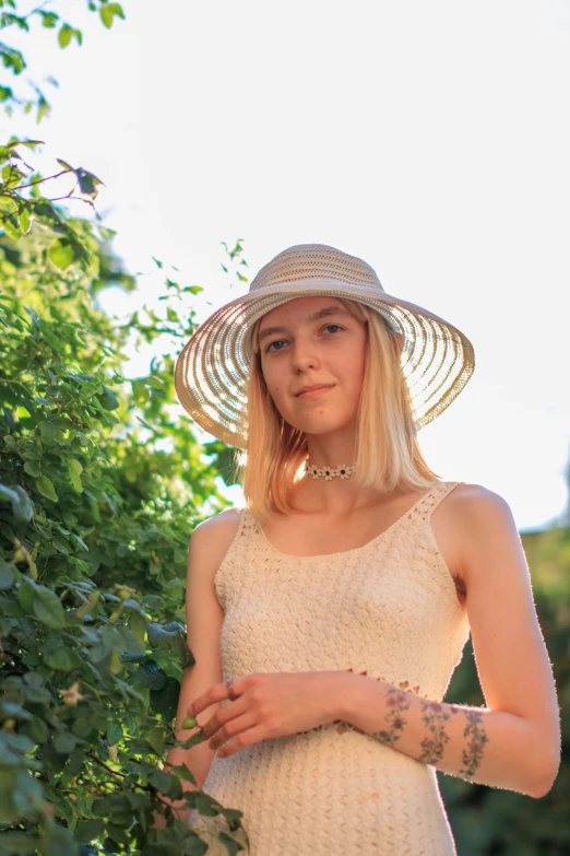 a beautiful young woman wearing a white dress and hat