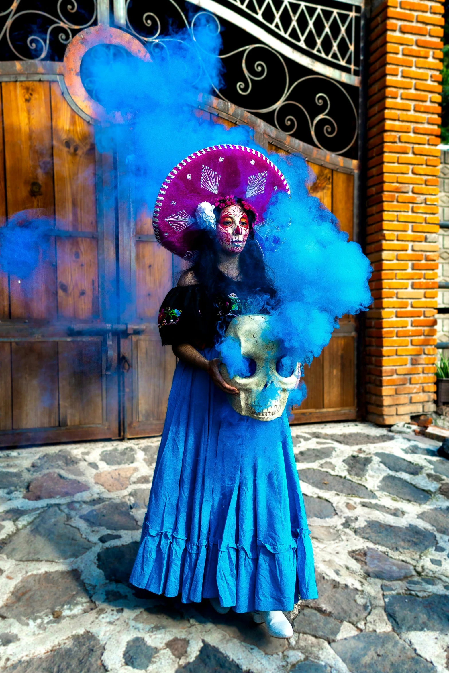 a woman dressed in blue stands under an umbrella