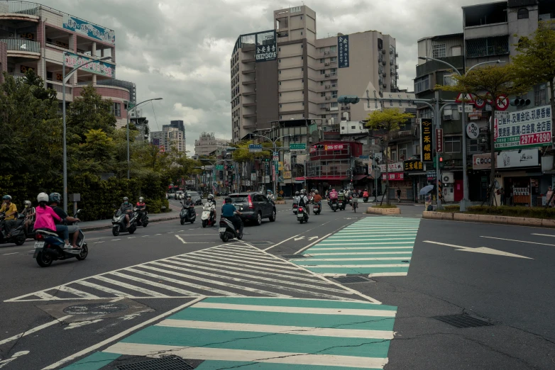 some people on motor bikes some buildings and trees