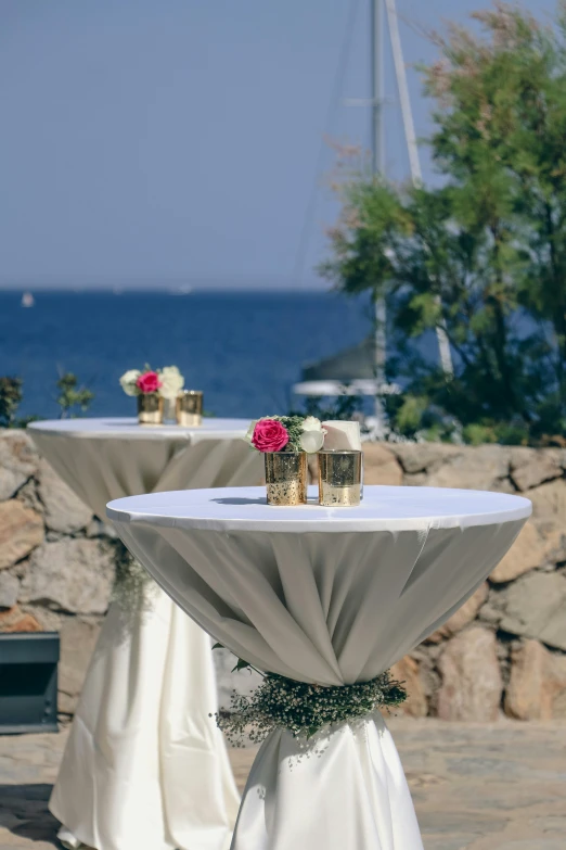 a table with flowers on it is next to the ocean