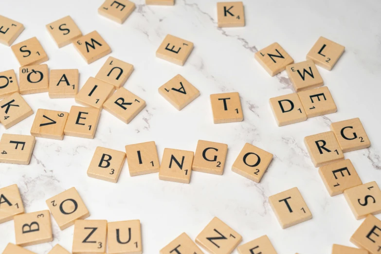 scrabble letter words are laid out on a white surface