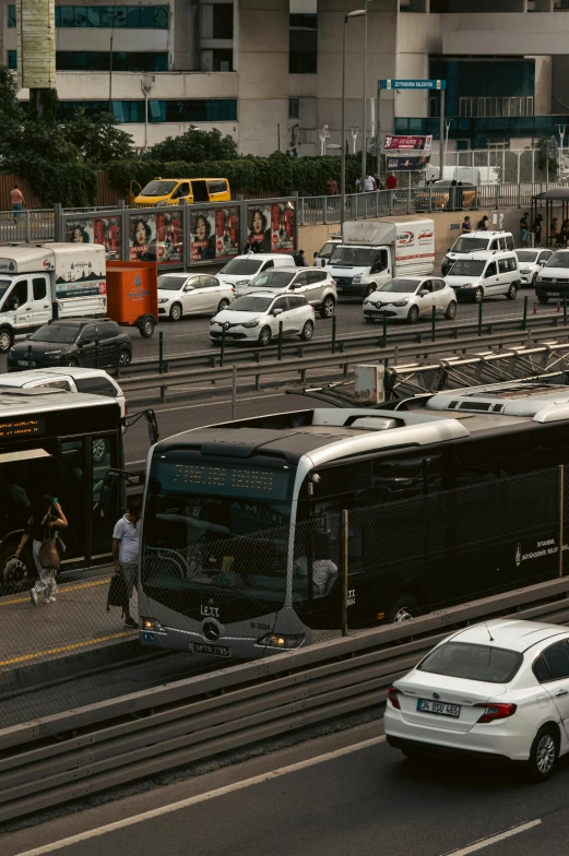 large buses and cars on the side of a road