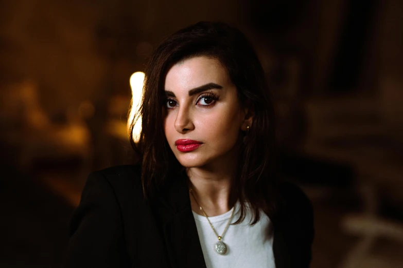 a woman with a necklace looking at the camera