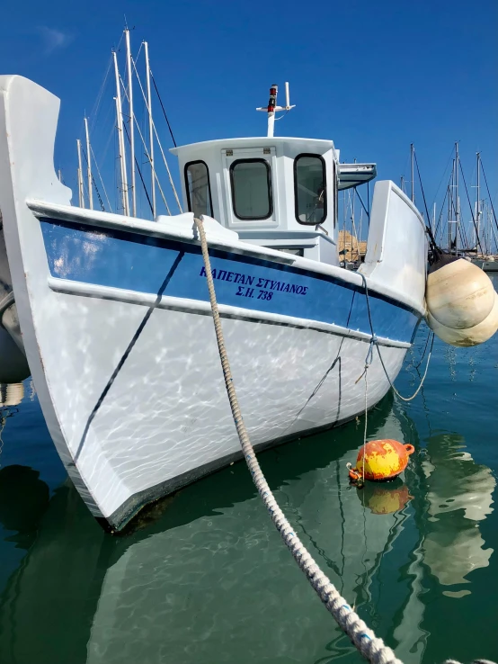 a blue and white boat moored to a dock