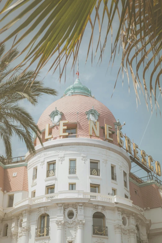 a white and orange building with palm trees in front