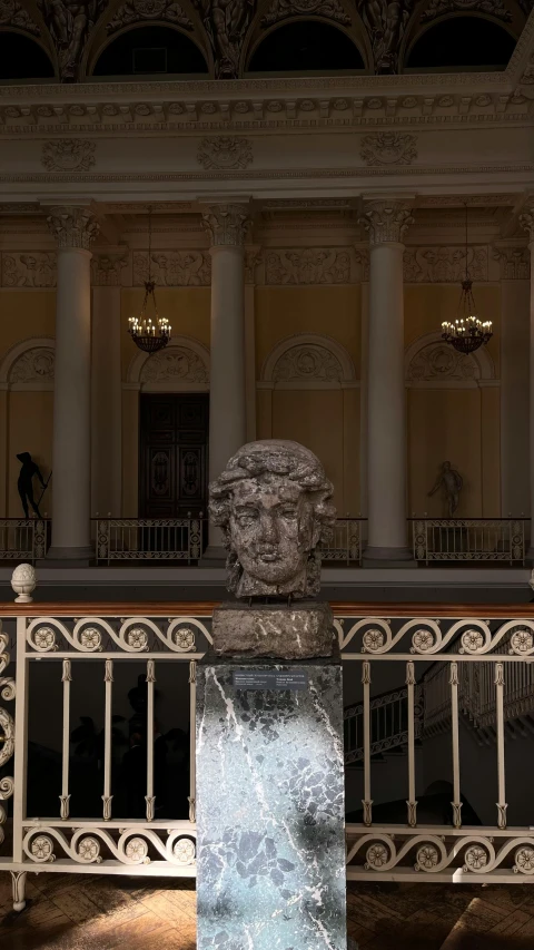 an elaborate, ornate looking balcony with columns and a sculpture in front of it