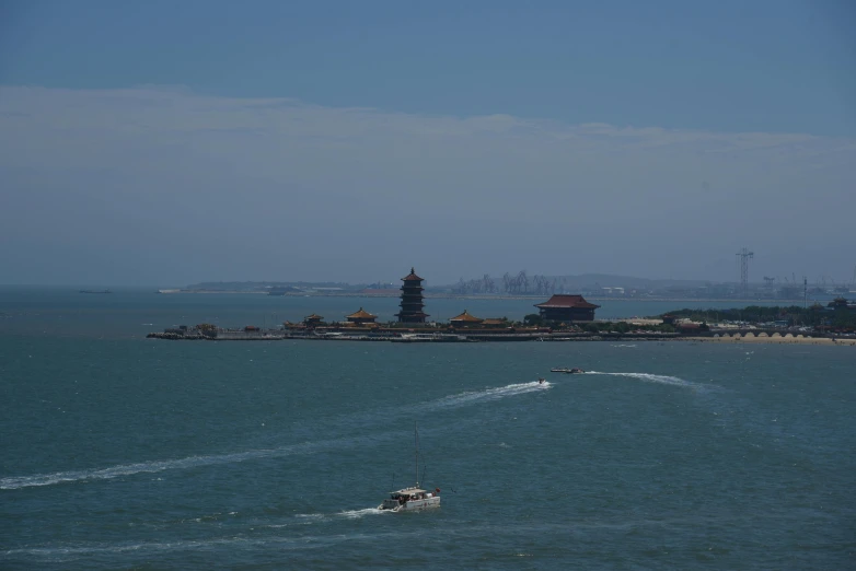 the view of the beach with boats, boats, and lighthouses in the distance