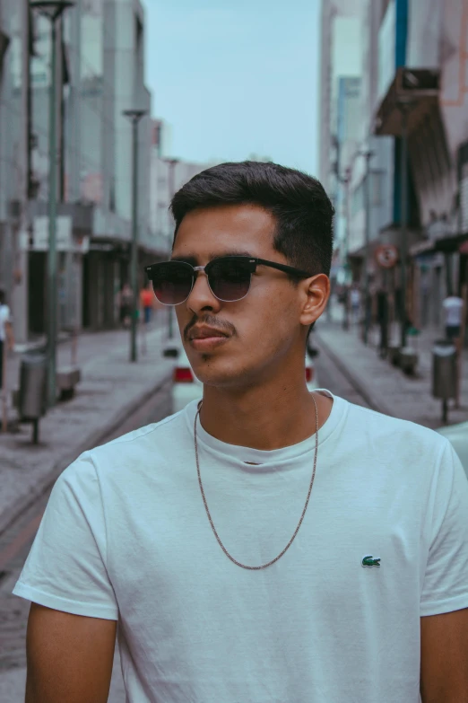 a young man wearing sunglasses on a street