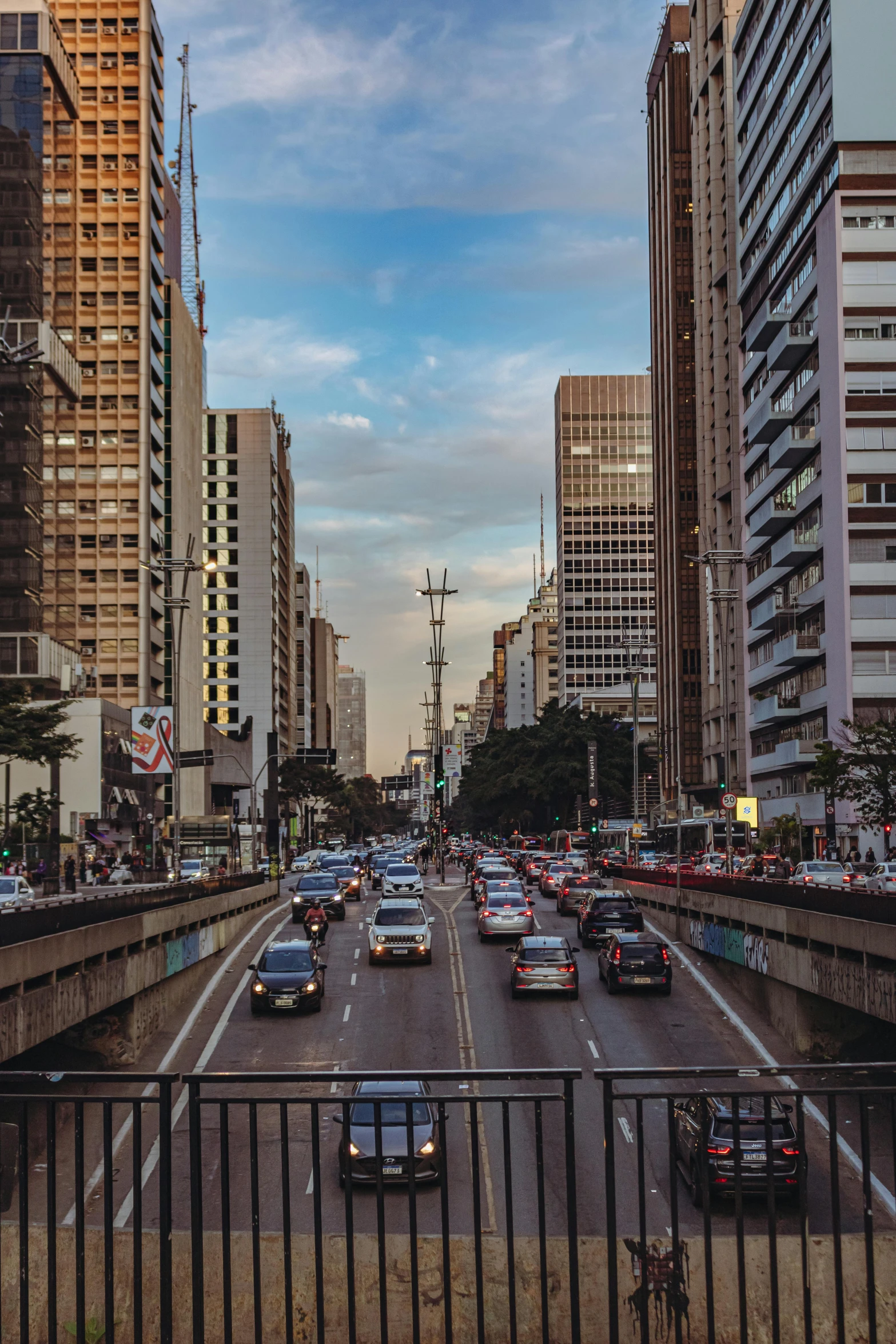 many cars traveling down a highway with tall buildings