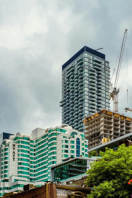 several buildings with cranes on top of them in the background