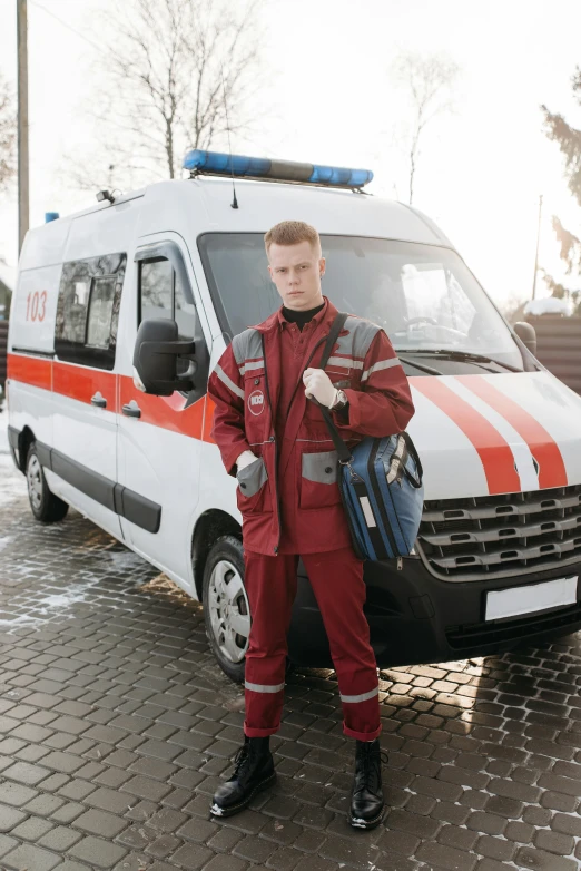 man in red suit standing in front of ambulance