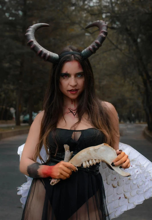 there is a woman dressed as a demon and holding horns