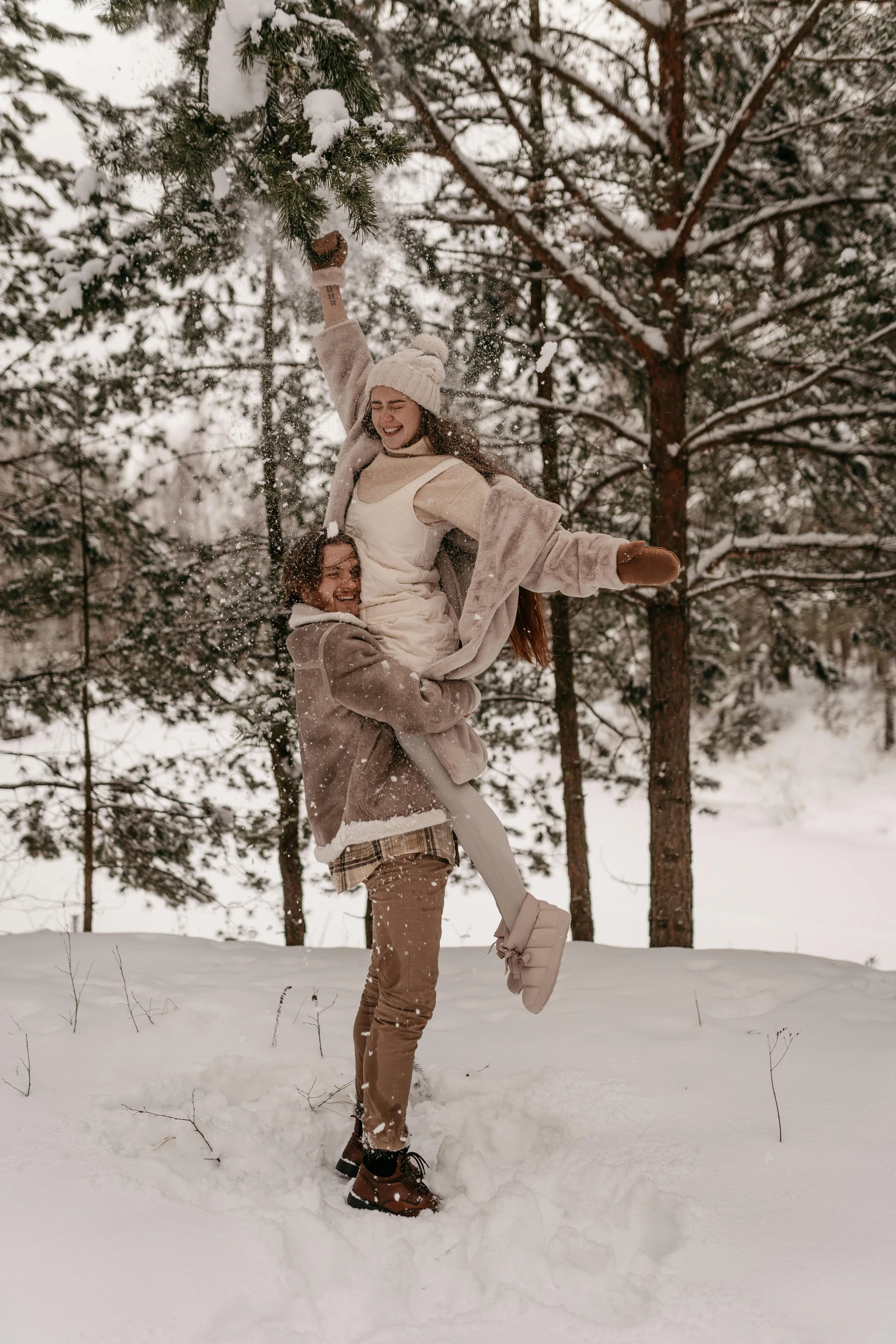 the young woman is kicking snow up on her head