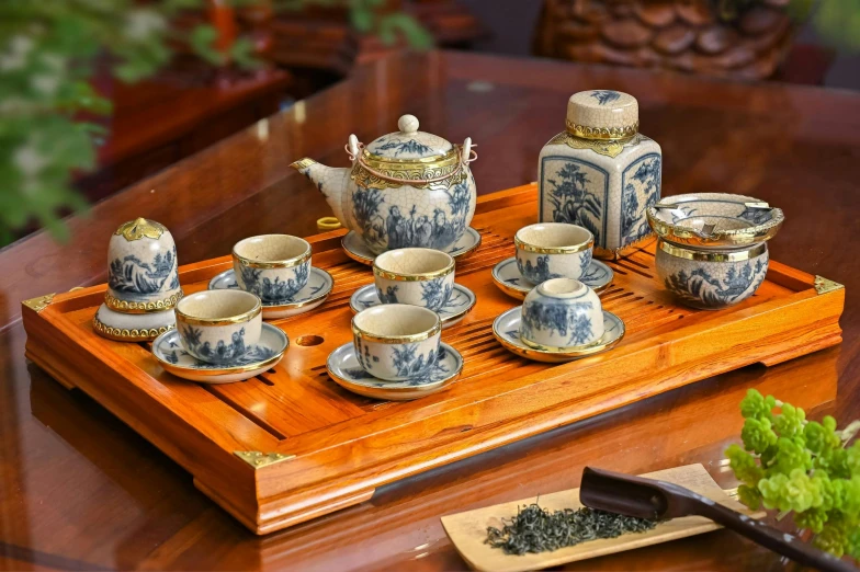 a wooden tray holding a set of porcelain tea and coffee cups