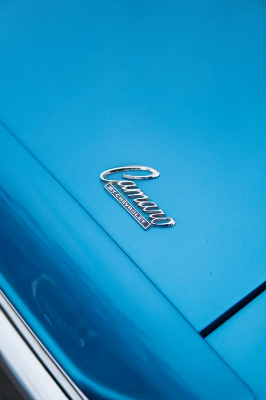 the emblem on a very old blue chevrolet