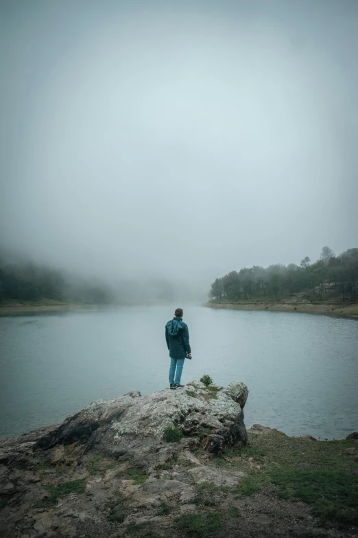 a person standing on a rock looking out at a large body of water