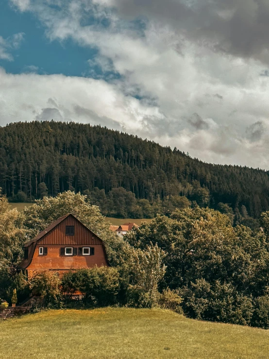 an old barn next to trees and bushes