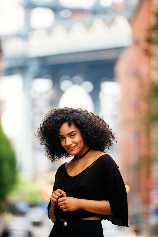 a woman standing on a sidewalk with her hands crossed