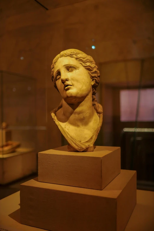 the bust of a young man that has been placed on blocks in a room