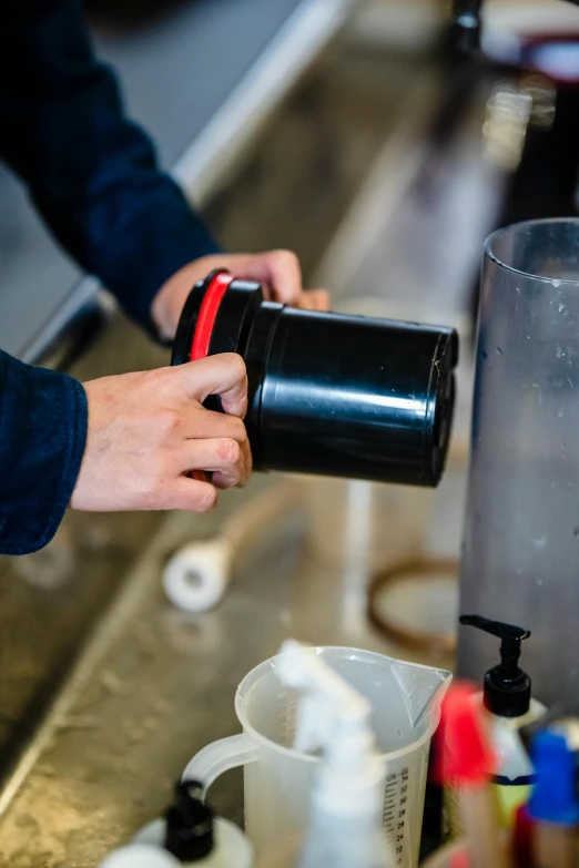 a person pours water into an empty mug