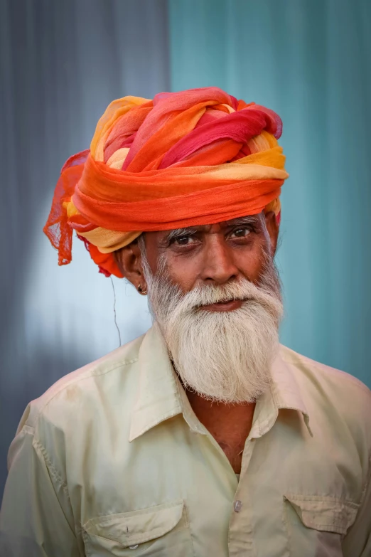 a man wearing a turban with orange and pink decorations