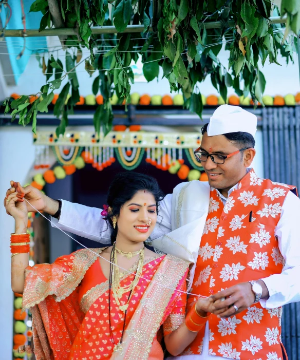 a man and woman dressed up for wedding with a backdrop full of flowers