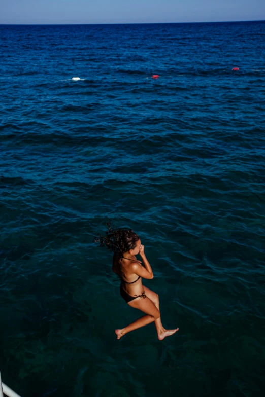 a woman swimming in the ocean, wearing a bikini