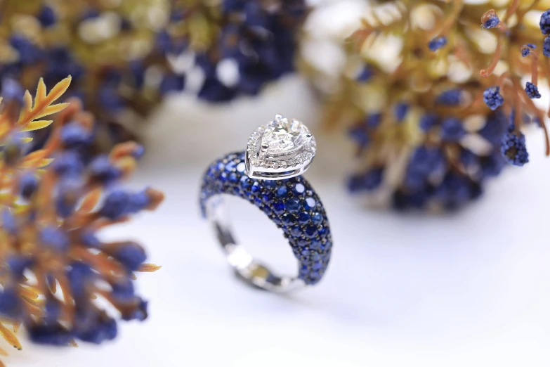 a white gold ring with diamonds and blue sapphire