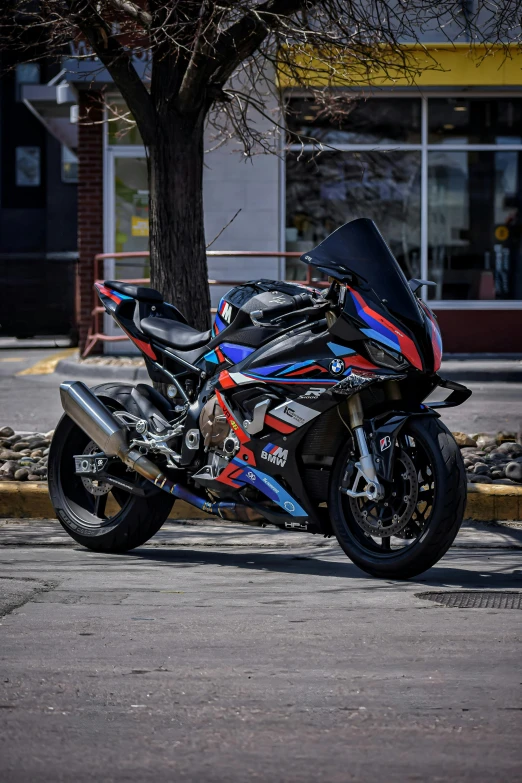 a motorcycle with a colorful decal on it is parked in front of a tree