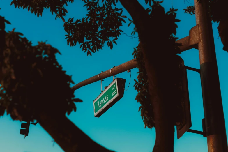 there is a green street sign that is hanging off the side of a road