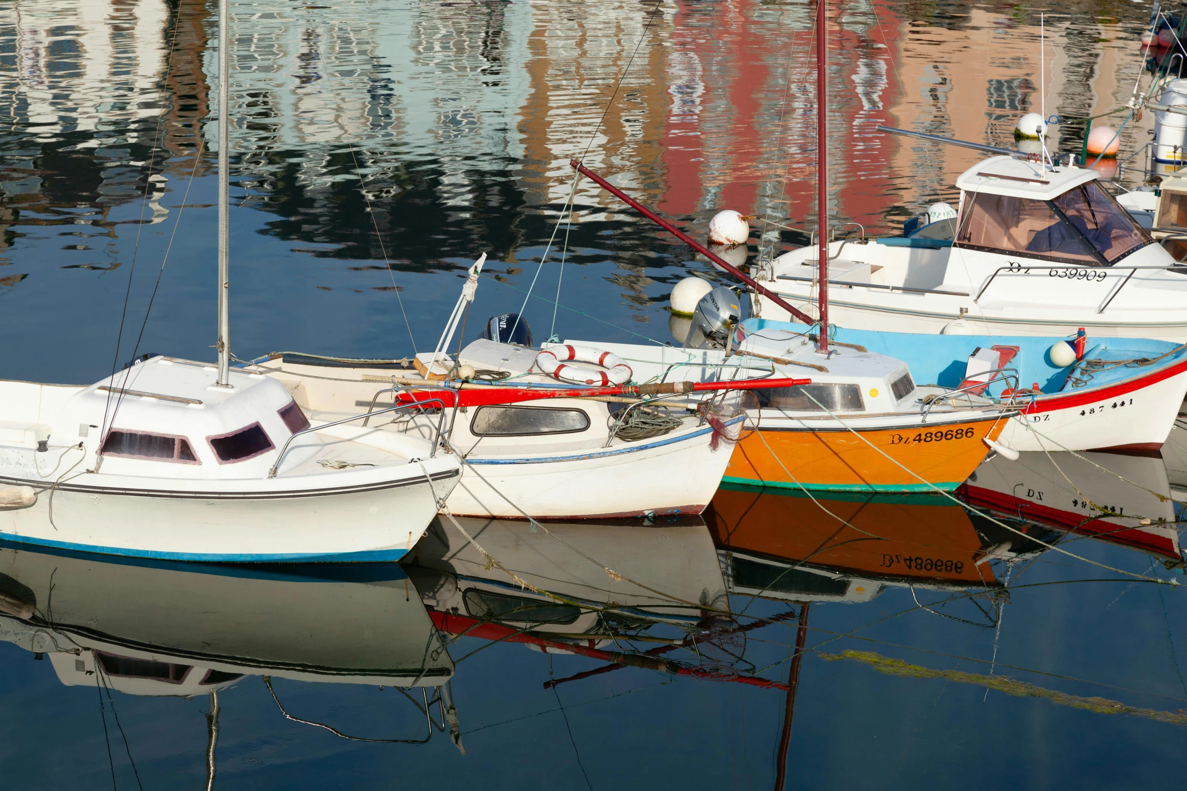 several boats in water reflecting each other