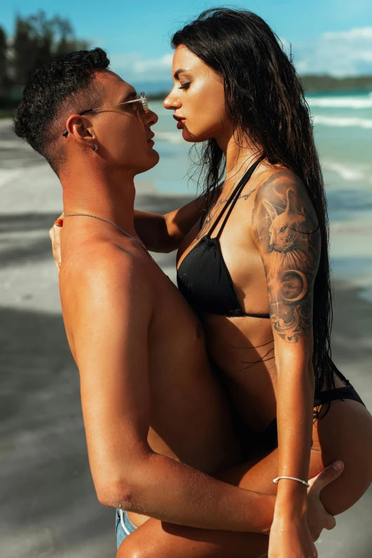 a man and woman sharing a kiss on the beach