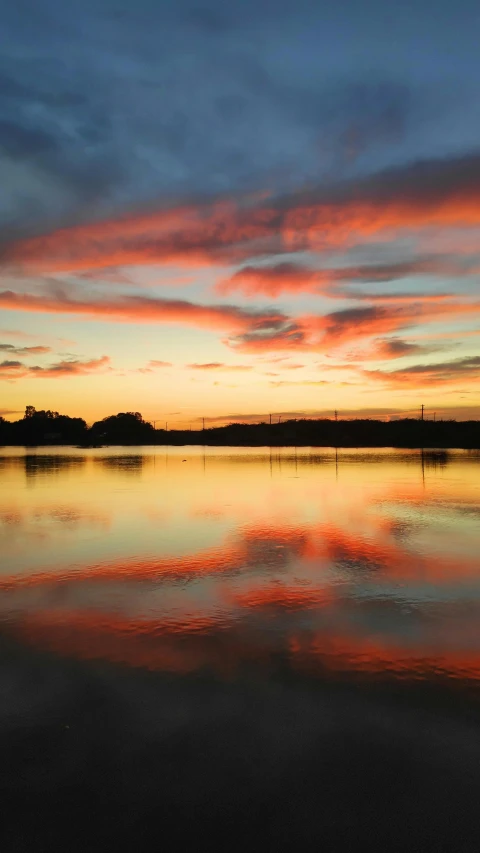 a calm lake at sunset with some reflections on the water