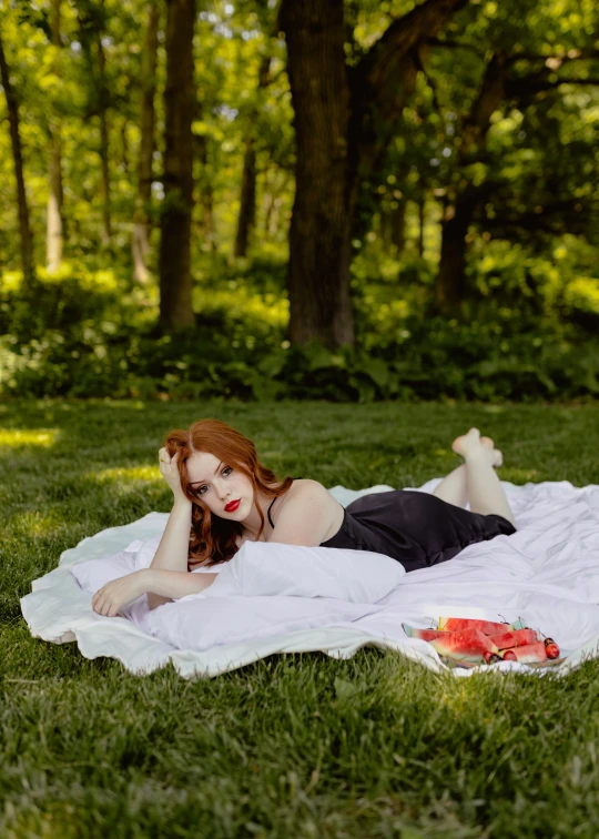 a young woman wearing black laying on a white blanket