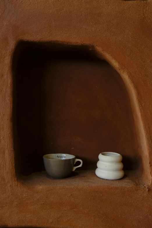 a couple of cups that are on a shelf