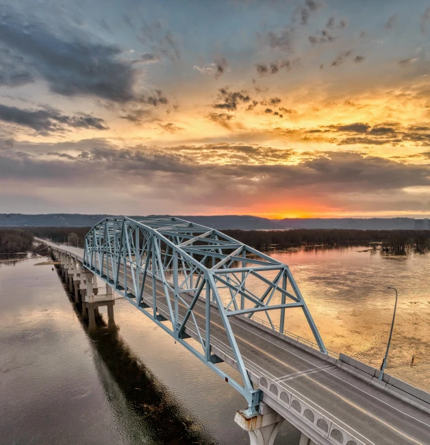 this is the sun rising over a bridge