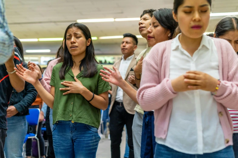 a group of people stand together in prayer