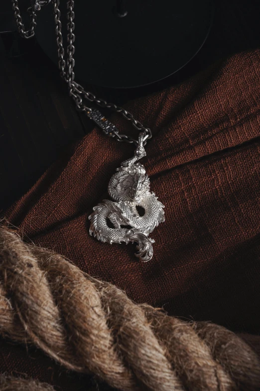 silver necklace with a metal flower, sitting on a red background