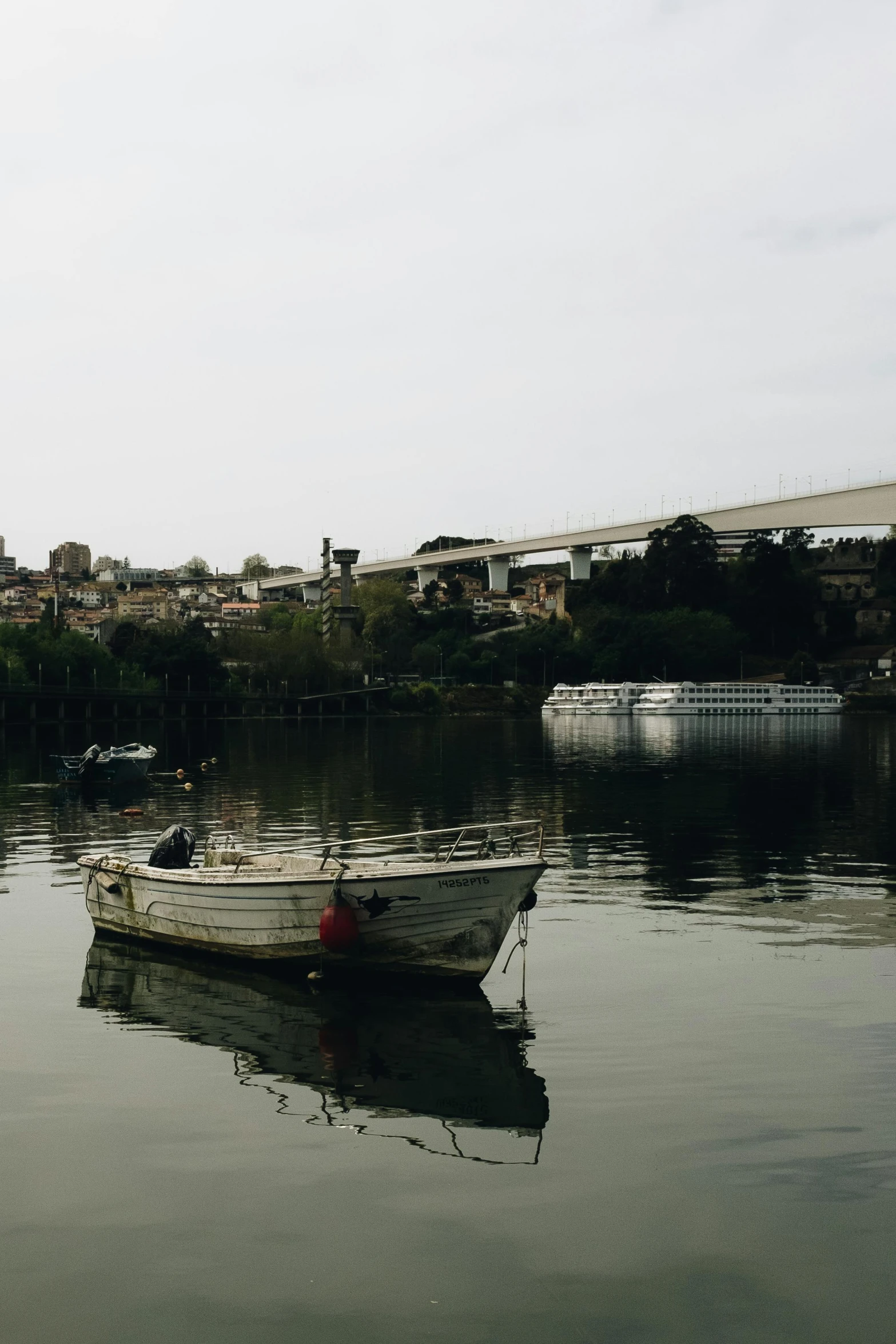 small white boat in calm water by some buildings